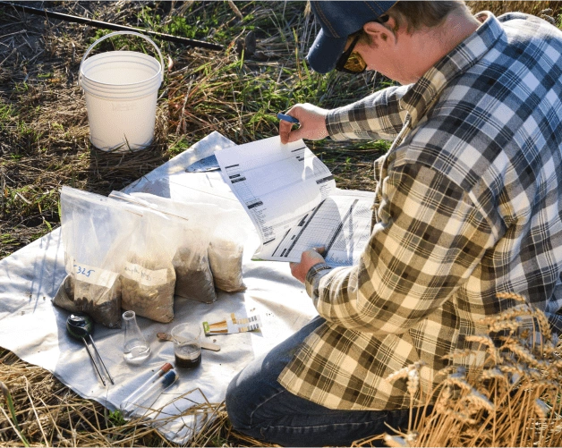 A man manages soil sample collection required for SOC baseline assessment in the field
