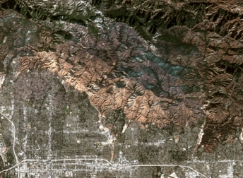 satellite view of the Eaton fire and its aftermath, where the scorched land appears in shades of brown