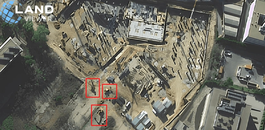 close-up satellite view of property with heavy machinery